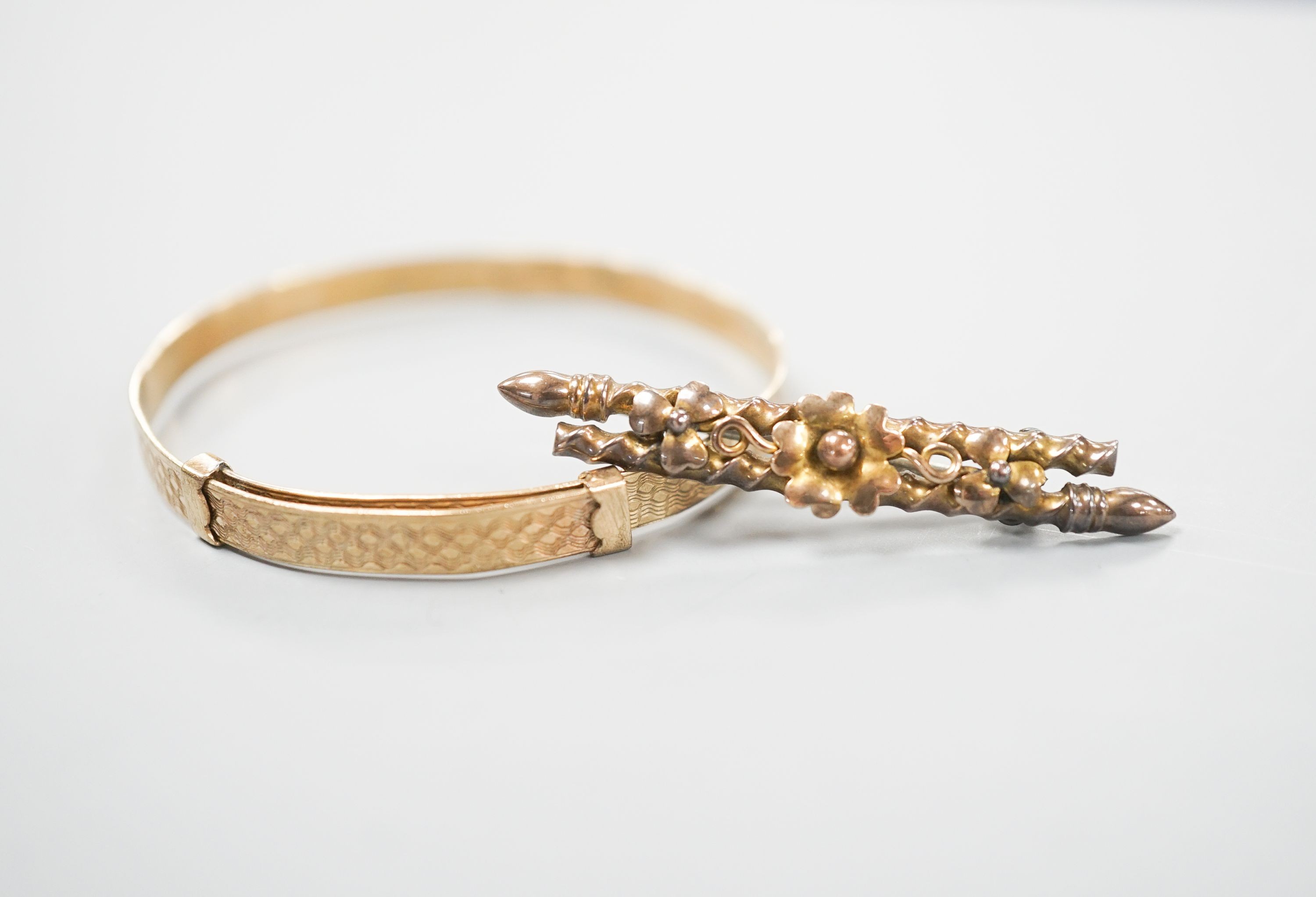 A modern 9ct gold child's bangle and a late Victorian 9ct gold bar brooch, gross 6.7 grams.